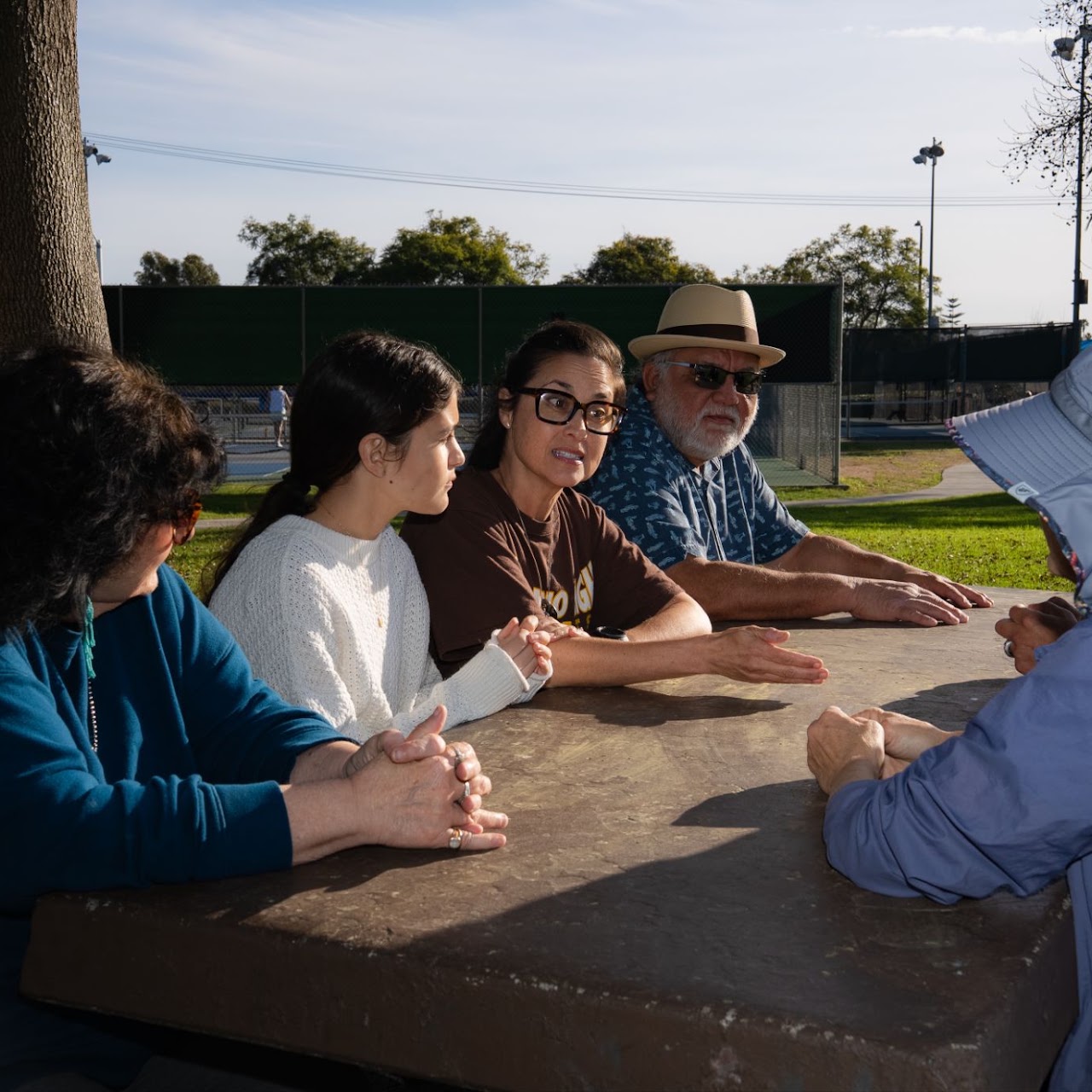 Oceanside residents gathered outdoors discussing neighborhood safety and emergency preparedness with Emily Gonzales